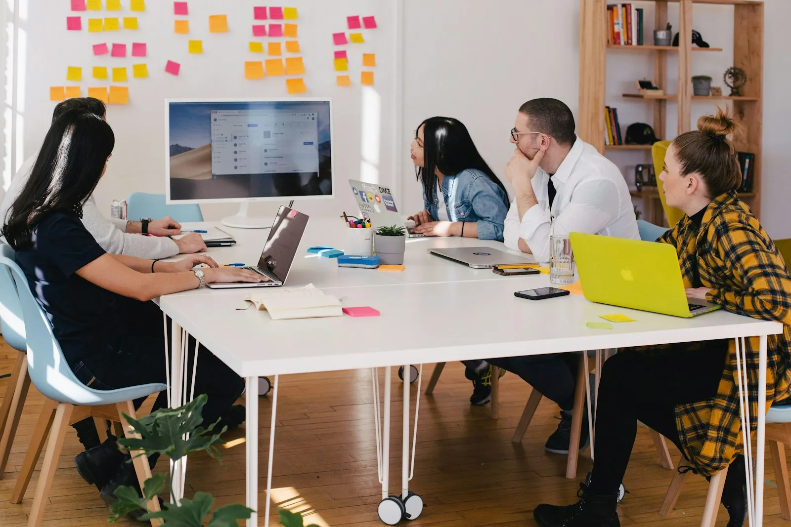 Team meeting where colleagues review work together around a table